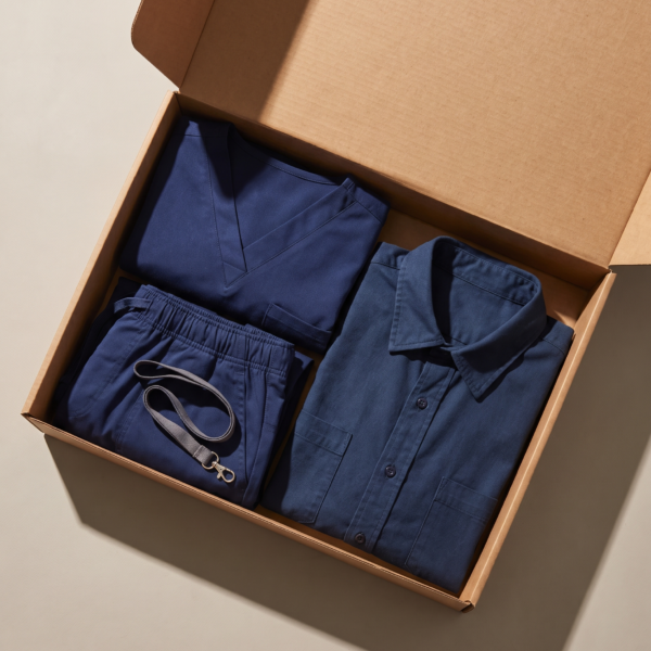 Folded scrubs, workshirt, and lanyard flat lay